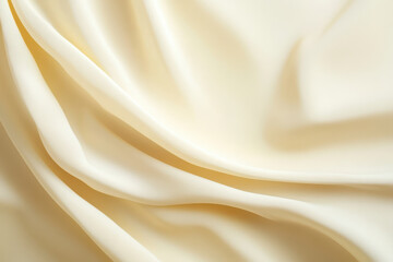 Obraz premium Elegant and soft cream-colored fabric draped gracefully, perfect for fashion and interior design projects.