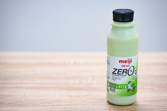 PATHUM THANI, THAILAND - November 29, 2024: Illustrative and Editorial image of Meiji milk green tea with on wooden table.