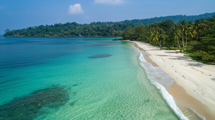 Aerial view of a beautiful tropical beach with crystal-clear water, showcasing pristine sand and vibrant blue hues.