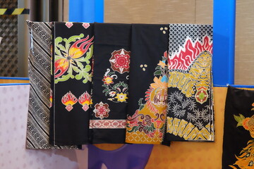 An array of Indonesian batik shirts and batik cloth hangs on the racks, displaying a variety of patterns and colors.