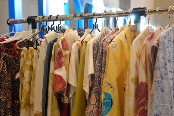 An array of Indonesian batik shirts and batik cloth hangs on the racks, displaying a variety of patterns and colors.