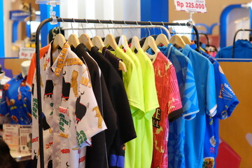 An array of Indonesian batik shirts and batik cloth hangs on the racks, displaying a variety of patterns and colors.