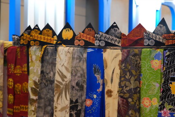 An array of Indonesian batik shirts and batik cloth hangs on the racks, displaying a variety of patterns and colors.