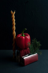 Still life on black background with wallet red anemones, red objects and pine branches symbolizing...