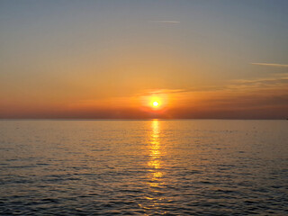 A captivating view of the Mediterranean Sea during sunset, with the golden hues of the sun reflecting on the calm waters.