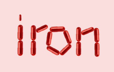 Creative idea for iron anemia concept. Supplement of ferritin in red capsule. Word with capsule representing iron supplementation for treating iron anemia.