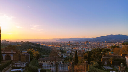 Fototapeta premium A breathtaking panoramic view of Florence at sunset, with the iconic Duomo and Brunelleschi's Dome dominating the skyline. The warm golden light casts a magical glow over the city, highlighting its hi
