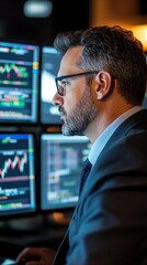 Obraz premium Business professional analyzing complex financial data on multiple computer screens in an office setting, focused on fluctuating stock market trends and analytics.