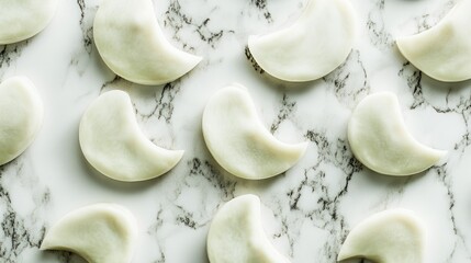 Overhead view of organic broad beans arranged on a sleek marble surface highlighting texture and natural shapes