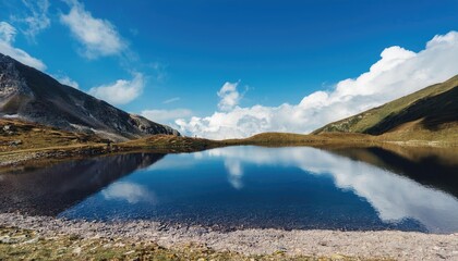 Fototapeta premium Mountain Lake Reflecting the Blue Sky and Clouds