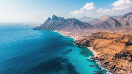 Fototapeta premium Mountainous coastline with clear blue water, ideal for capturing the beauty of nature. This image of the scenic mountainous coastline invites exploration and adventure.