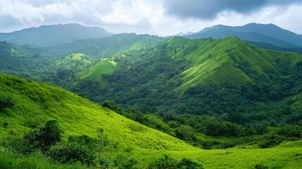 Obraz premium Lush green hills create a stunning backdrop with a captivating mountaintop view, offering a perfect blend of natures beauty and serenity. Lush green hills invite exploration and tranquility.