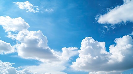 Obraz premium A vibrant blue sky adorned with fluffy white clouds creates a serene atmosphere. The blue sky and white clouds together offer a beautiful backdrop with ample copy space for text.