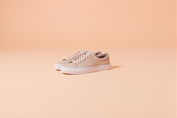 Simple pair of sneakers on a pastel peach surface