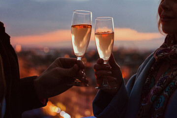 couple with two glasses of champagne in night city, hands close up