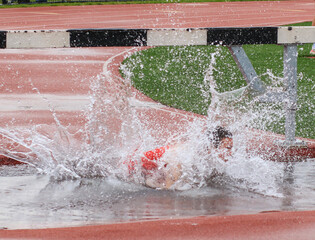 Athlete Falls Into Water During Hurdle Race at Local Track Event