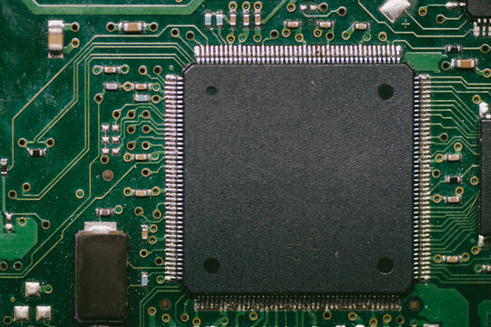A black chip on a green circuit board