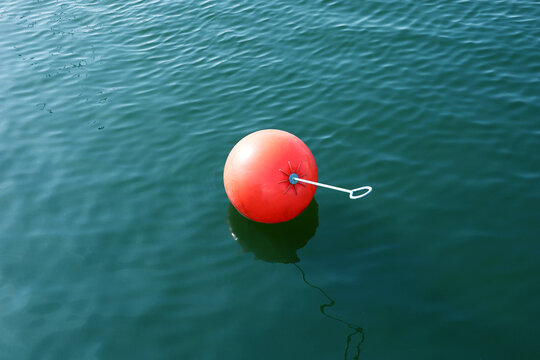 Orange water trail marker buoy floating on the water surface