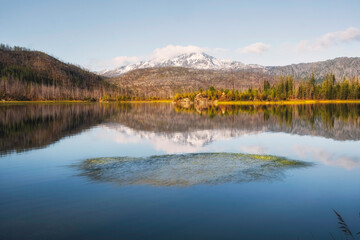 Beautiful landscape with mountain lake Arashan, where the peak with the first snow is reflected in the water in Kazakhstan. Mountain Altai in Katon Karagai park.