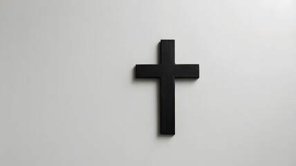 Obraz premium Black Wooden Cross on Clean White Surface for Home Decor