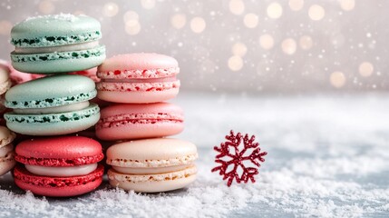 Obraz premium Colorful macarons are stacked attractively on a snowy surface, with a decorative snowflake, creating a festive winter atmosphere.