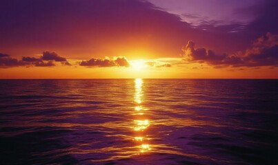 Obraz premium A serene sunset over the ocean, reflecting vibrant colors on the water.