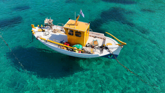 Aerial photo from traditional picturesque fishing boat on turquoise clear sea as seen from top in island of Paros, Cyclades, Greece