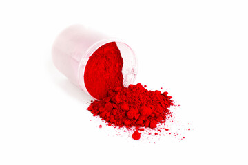 Vibrant Red Powder Spills From a Container on a White Surface During Crafting