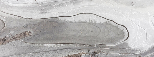 Ice crust on the surface of a puddle, background