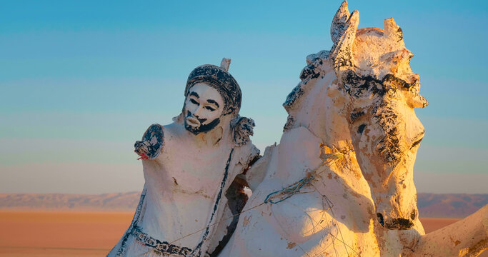 Horse and knight statue at the bottom of early existed Chott el Djerid salted lake. Statues in deserted parts of african continent.