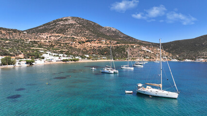 Obraz premium Aerial drone photo of picturesque seaside fishing village of Vathy featuring landmark chapel of Taxiarchis, Sifnos island, Cyclades, Greece