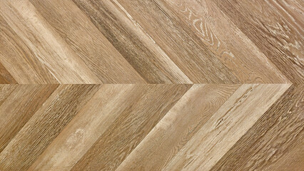 Close up of natural brown herringbone wood pattern. Gray fishbone wood tile pattern on a floor or wall for design background.