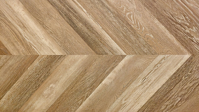 Close up of natural brown herringbone wood pattern. Gray fishbone wood tile pattern on a floor or wall for design background.