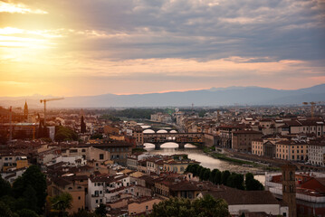 Fototapeta premium Panoramic view of river and bridge in Florence city, Italy on sunset