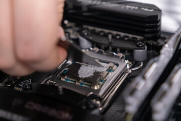 even application of thermal paste on cpu, close-up view of precise spreading with spatula, focusing...