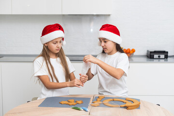  Kids decorating cookies in the kitchen.