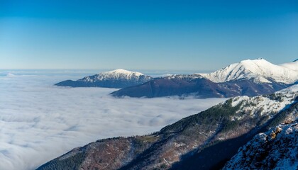 산꼭대기 풍경 눈으로 덮인 산봉우리와 그 아래로 펼쳐진 운해
