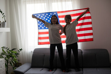 cheerful adorable kids standing under american flag and looking at camera 