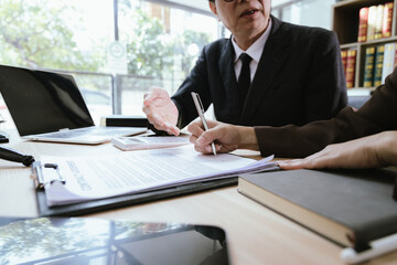 Lawyers discuss legal documents, explaining the terms of their consultation with a businesswoman...