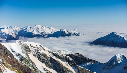 산꼭대기 풍경 눈으로 덮인 산봉우리와 그 아래로 펼쳐진 운해