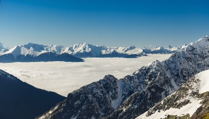 산꼭대기 풍경 눈으로 덮인 산봉우리와 그 아래로 펼쳐진 운해