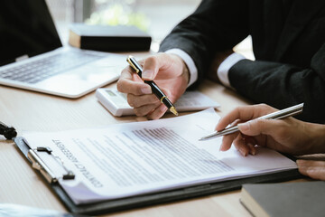 Close up of male lawyer working with contract documents and wooden hammer on table in courtroom....