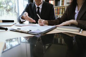 Close up of male lawyer working with contract documents and wooden hammer on table in courtroom. Justice and law. Judge in suit or lawyer working with documents. Law. Close up.