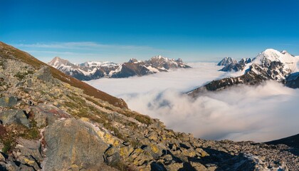 산꼭대기 풍경 눈으로 덮인 산봉우리와 그 아래로 펼쳐진 운해
