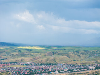 Mountain landscape in summer before the rain. Village near the mountains. Top view, drone photo.