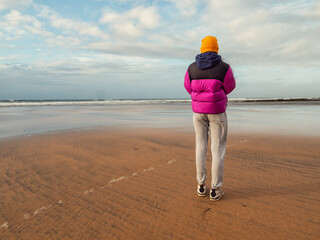 Teenager girl walking on stunning Fanore beach in county Clare, Ireland. Travel and tourism...