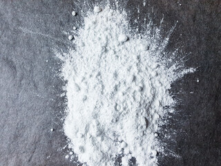 White drug, powder on black surface. Drug substance white powder concept.