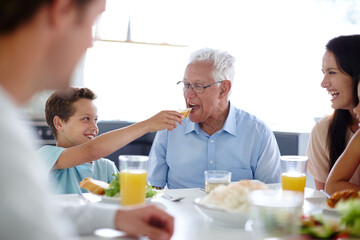 Family, generation and child at lunch in home for bonding at feast, festive celebration and holiday. Thanksgiving, Christmas party and grandparents with food for dinner, supper and eating together