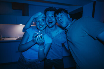 Obraz premium Group of friends having a lively birthday celebration at home, capturing the joy and fun of a party.