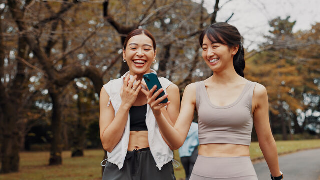 Japan, funny and women with smartphone, exercise and typing with social media. Sports meme, outdoor and friends with cellphone, fitness and technology for online reading, digital app or workout goals